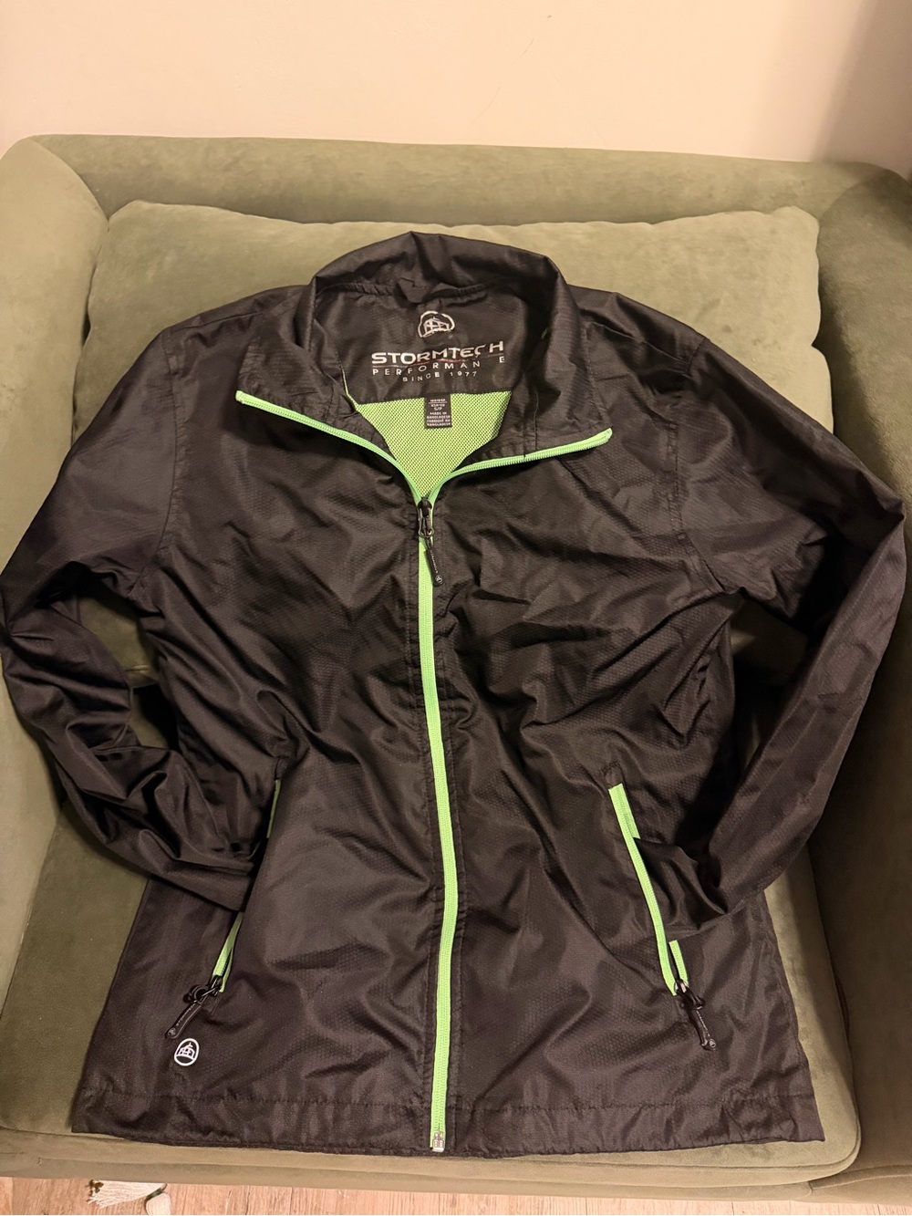 Stormtech black windbreaker jacket with neon green zipper and trim, size S